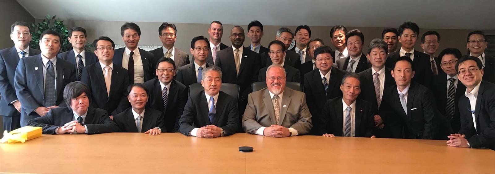 Japanese Bankers posing behind conference table