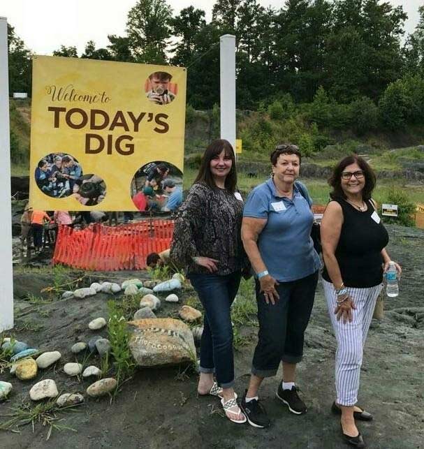 Three women posing in front of Today's Dig banner