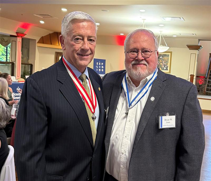 Two bank attendees with medals posing indoors