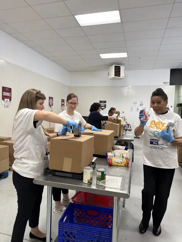 Women packing boxes and taping shut