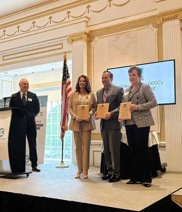 Three chamber members on stage, each with a plaque.