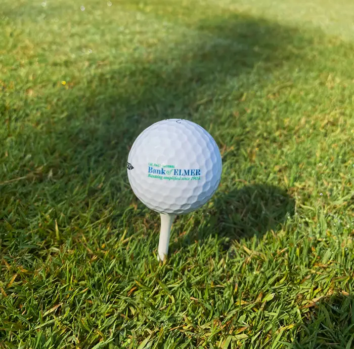 Golf ball with Elmer bank logo on it