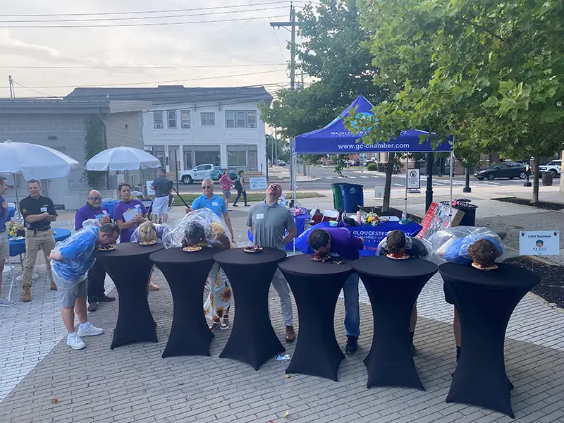Annual BBQ attendees participating in a pie eating contest.