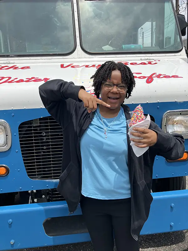 Elmer Bank employee pointing and holding pink ice cream cone
