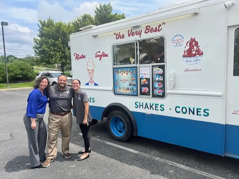 3 Elmer bank employees outside next to Mr. Softee truck.