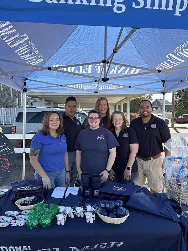 Group of Elmer employees under tent booth.