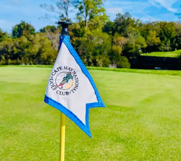 A white and black flag with the Cape May National Golf Club logo on it.