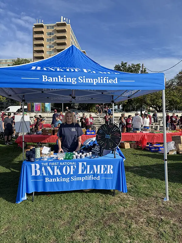 An employee of Elmer Bank posing for a picture at booth