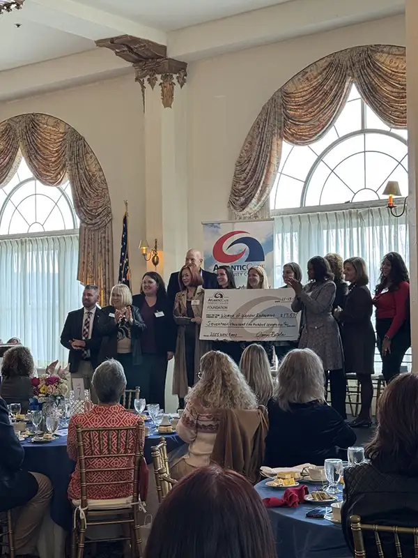 Group of people on stage accepting large check