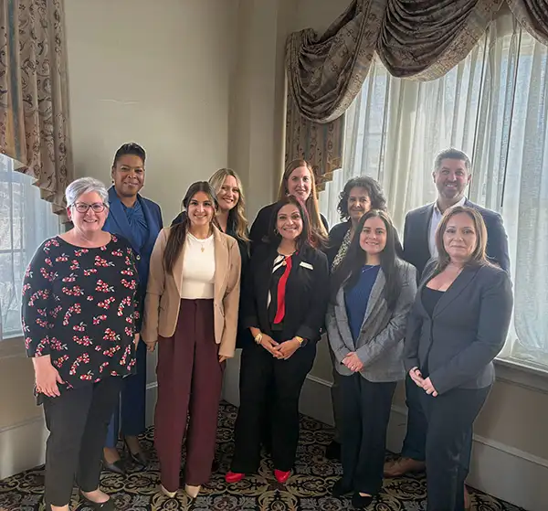 Group of people posing in corner of room