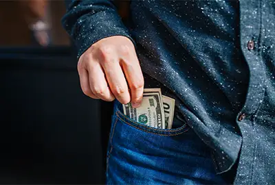 Man pulling bills out of his jean pocket.